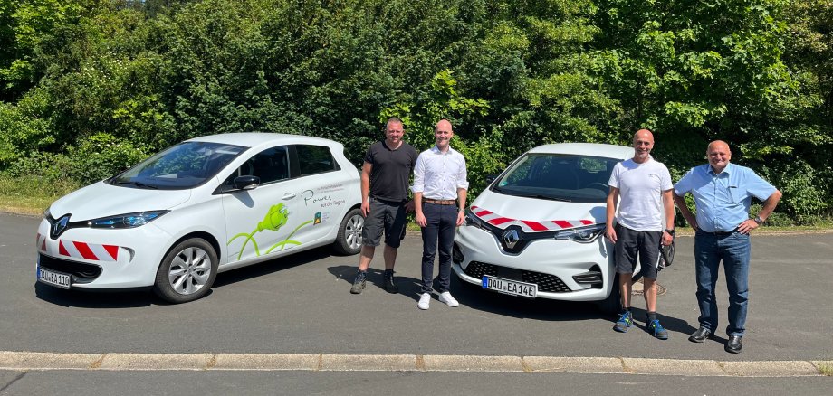 Personen vor neuen E-Fahrzeugen