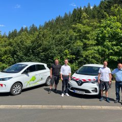 Personen vor neuen E-Fahrzeugen