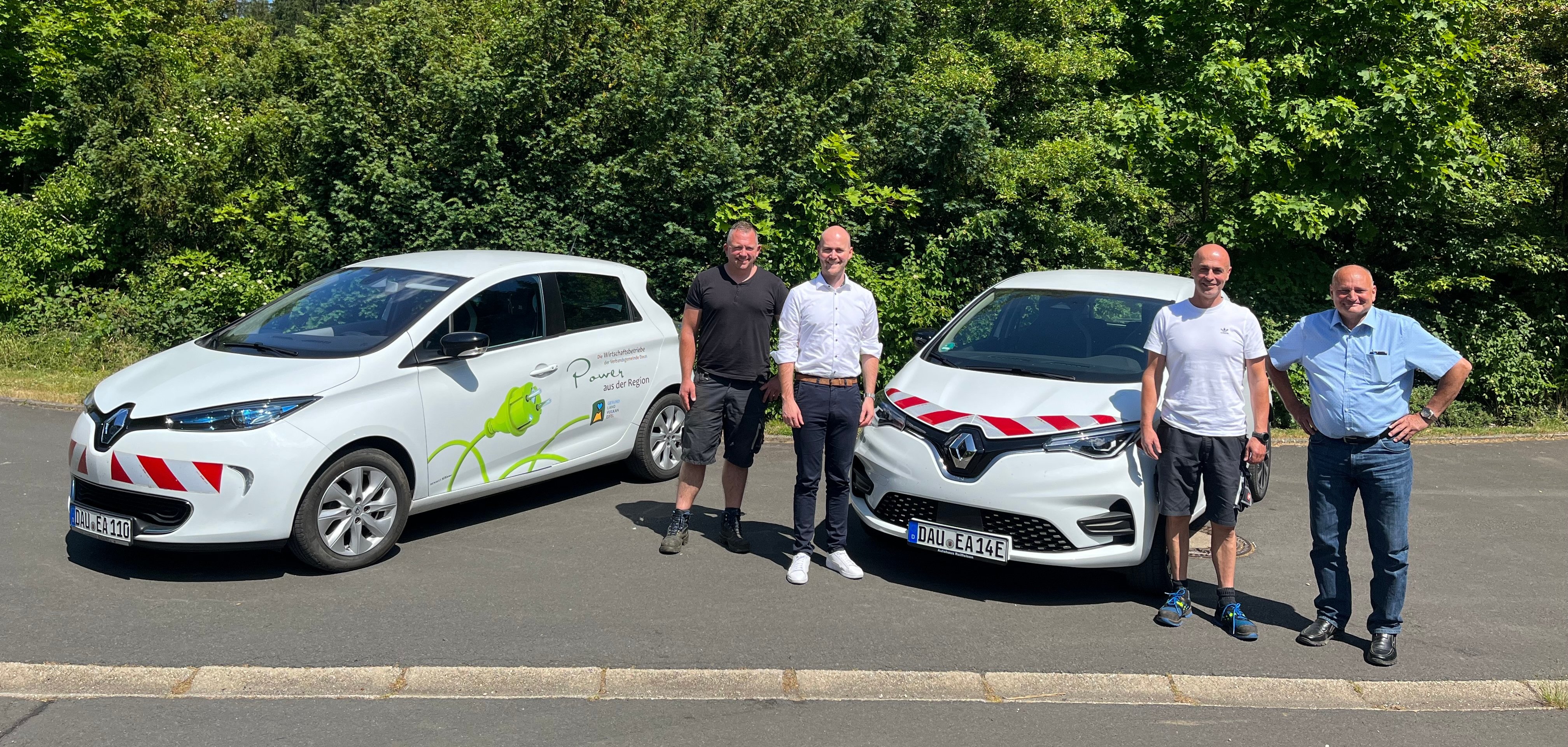 Personen vor neuen E-Fahrzeugen