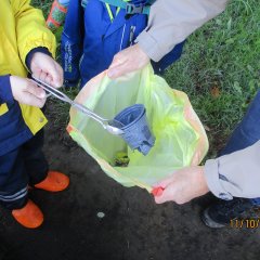 Kinder halten eine Mülltüte auf