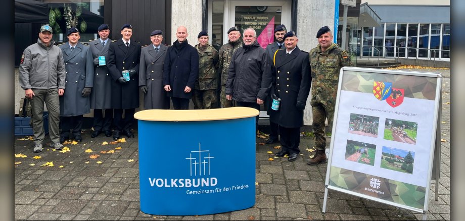 Soldaten und Personen am Stand für die Kriegsgräbersammlung