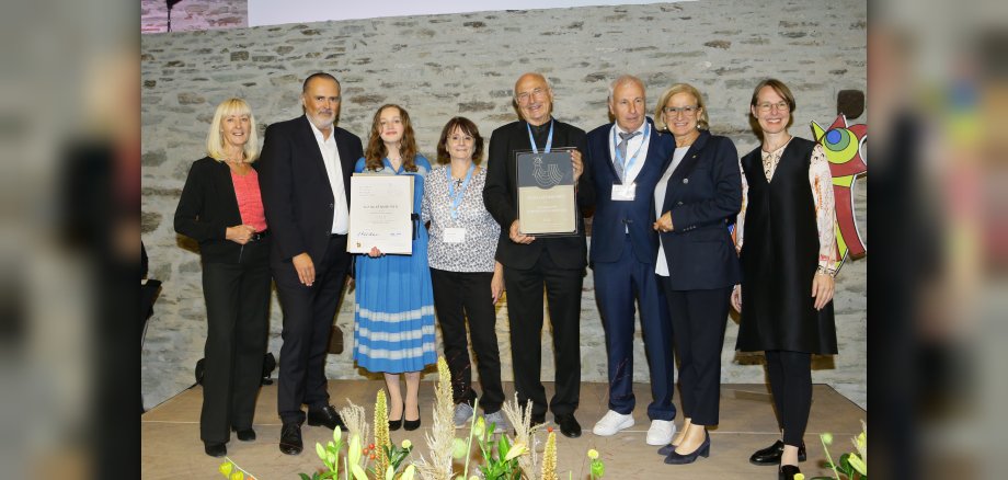 ©Lexi Personen beim Erhalt des europäischen Dorferneuerungspreises