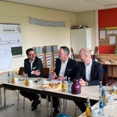 3 Personen bei Förderbescheidübergabe