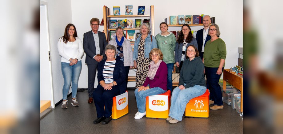 Darscheid_27 Personen vor Bücherregalen