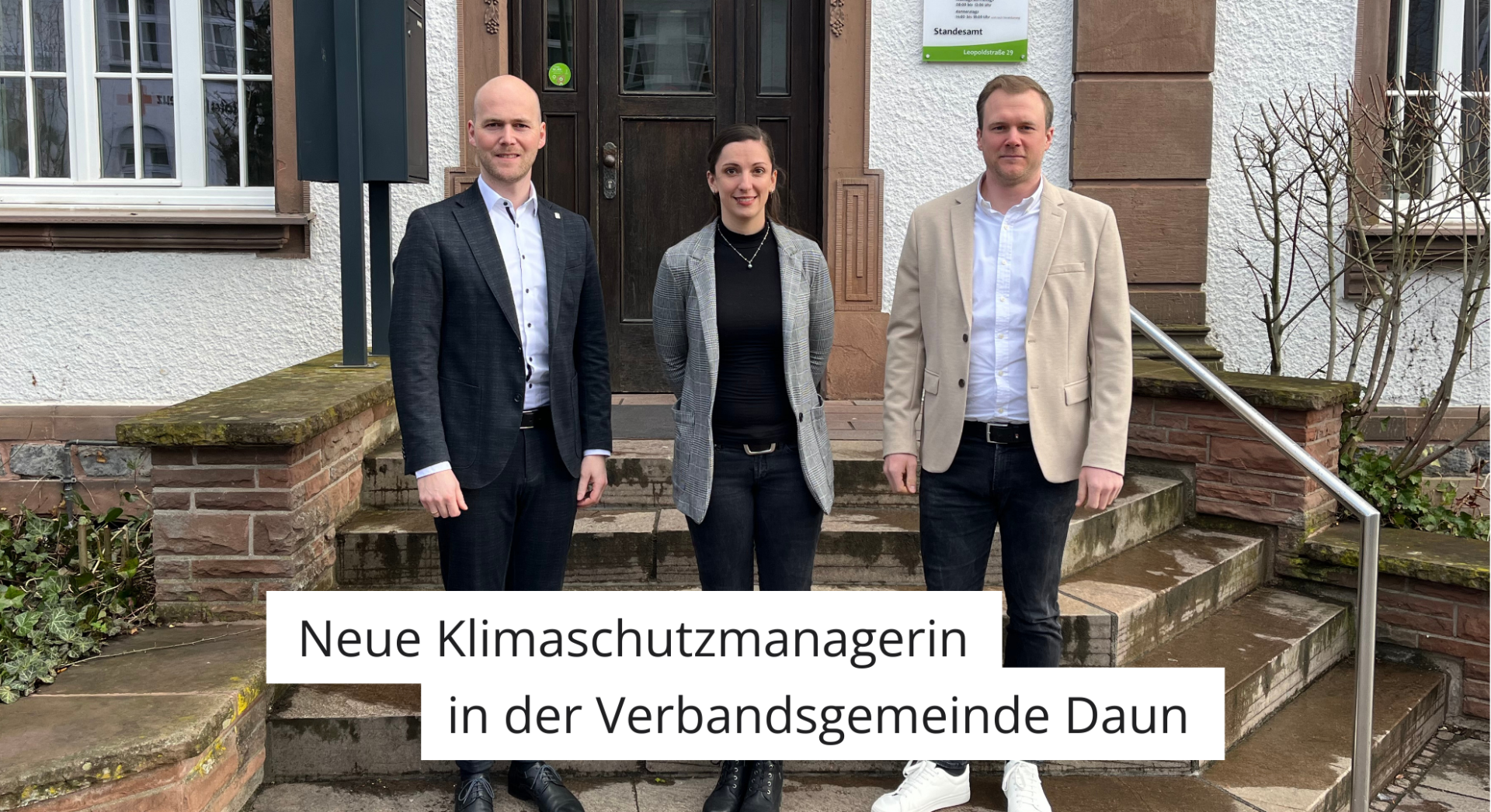 Drei Personen vor Verwaltungsgebäude