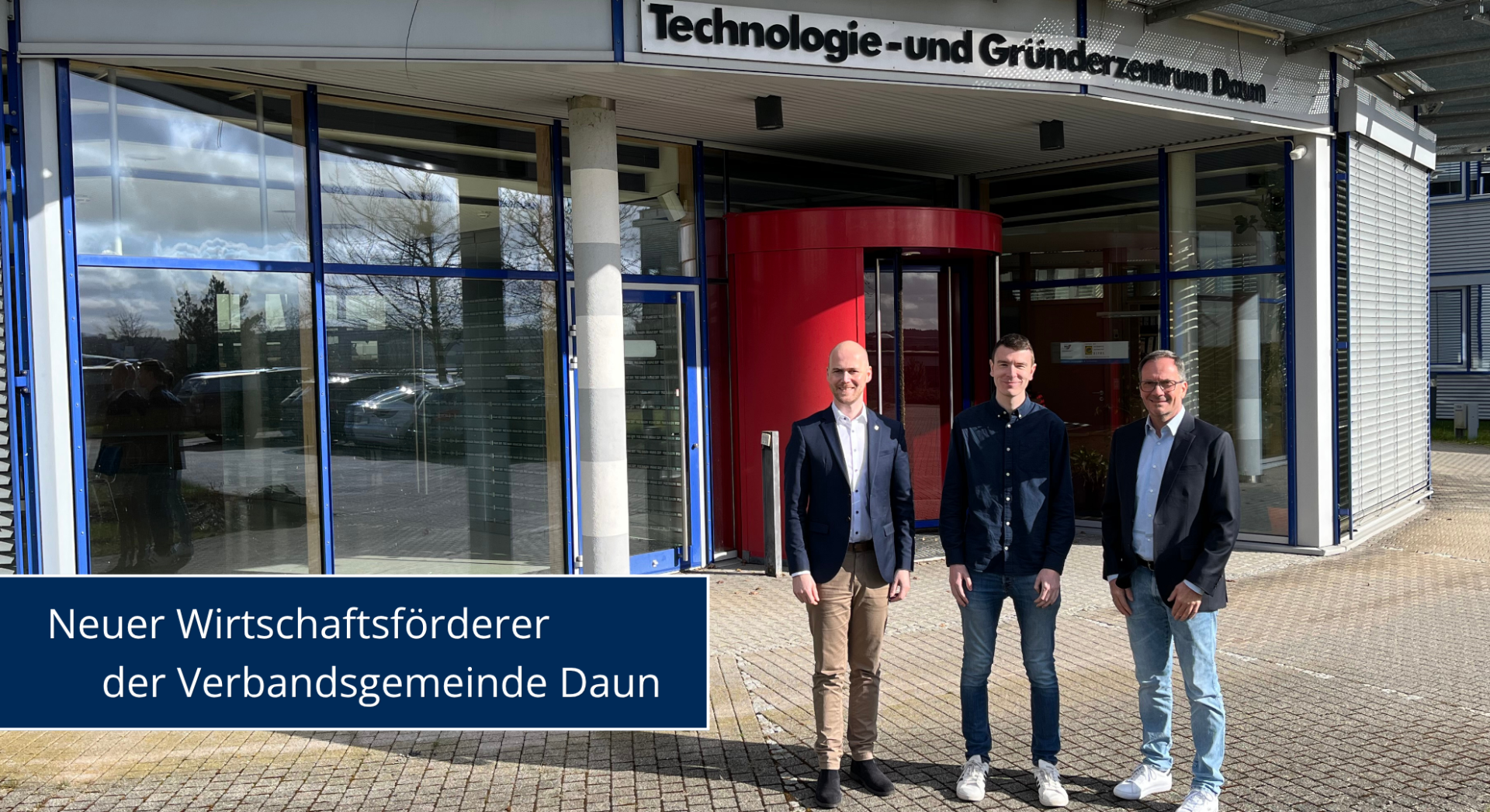 Drei Personen vor Gebäude