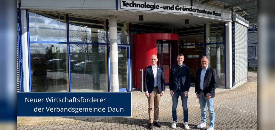 Drei Personen vor Gebäude