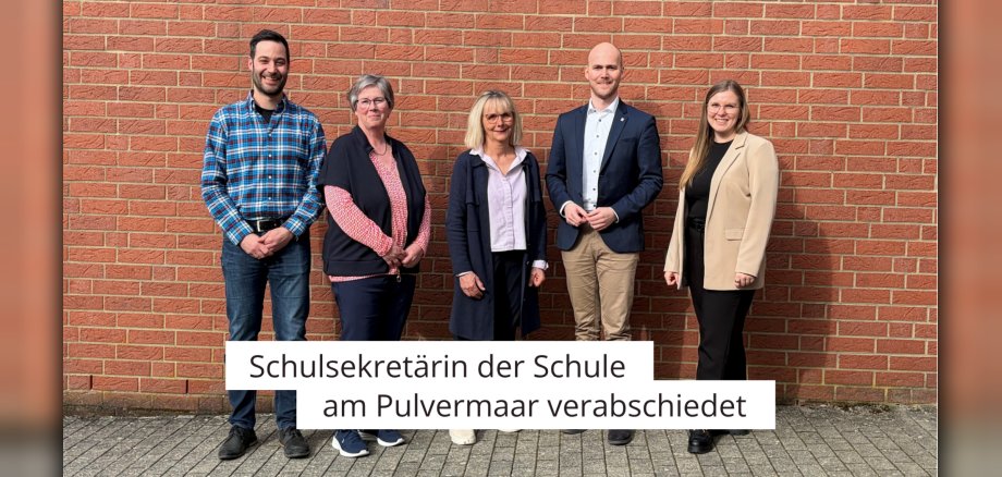 Fünf Personen vor Schulgebäude