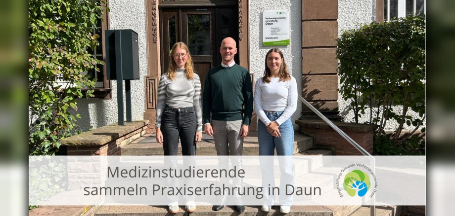 Drei Personen vor Verwaltungsgebäude