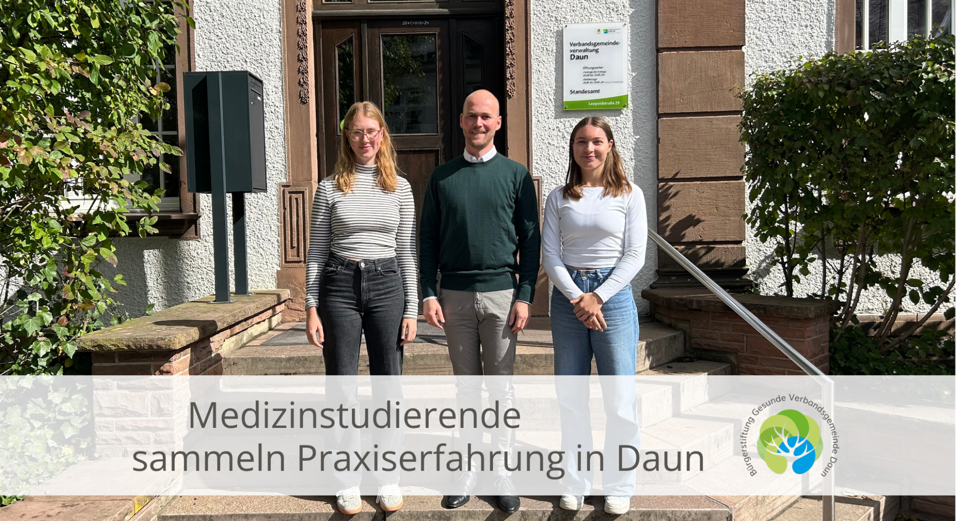 Drei Personen vor Verwaltungsgebäude