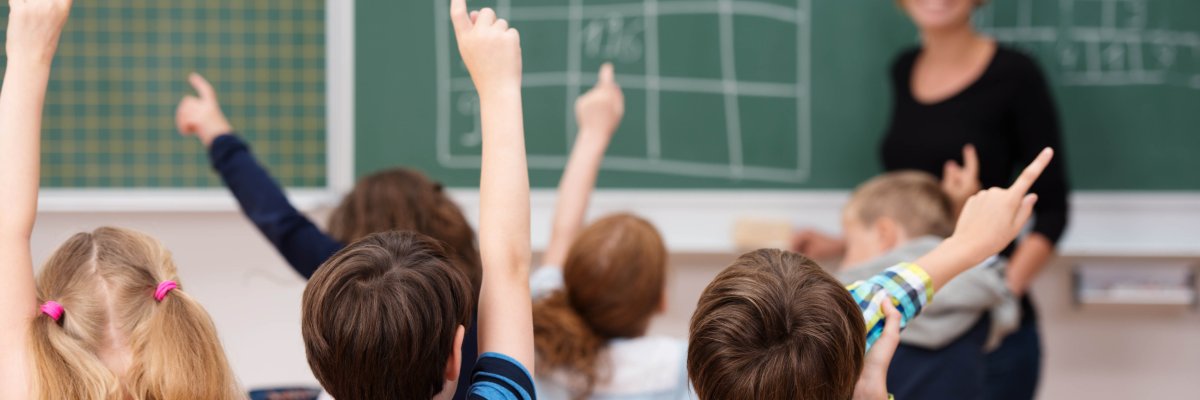 Symbolbild Kinder in Schule vor Tafel